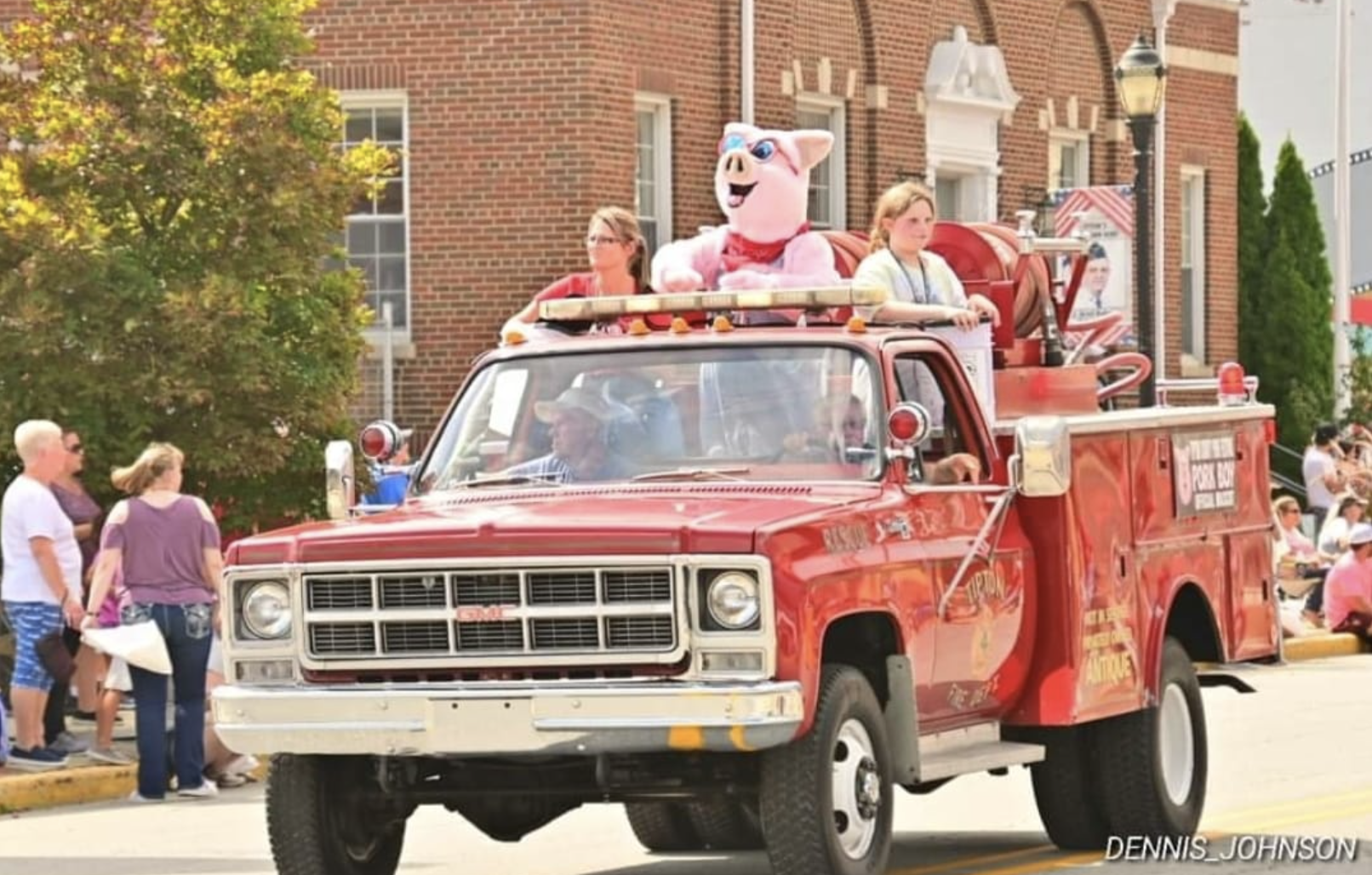 Image of pig mascot riding in fire truck