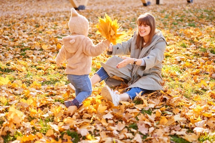 Child mom playing in leaves fall
